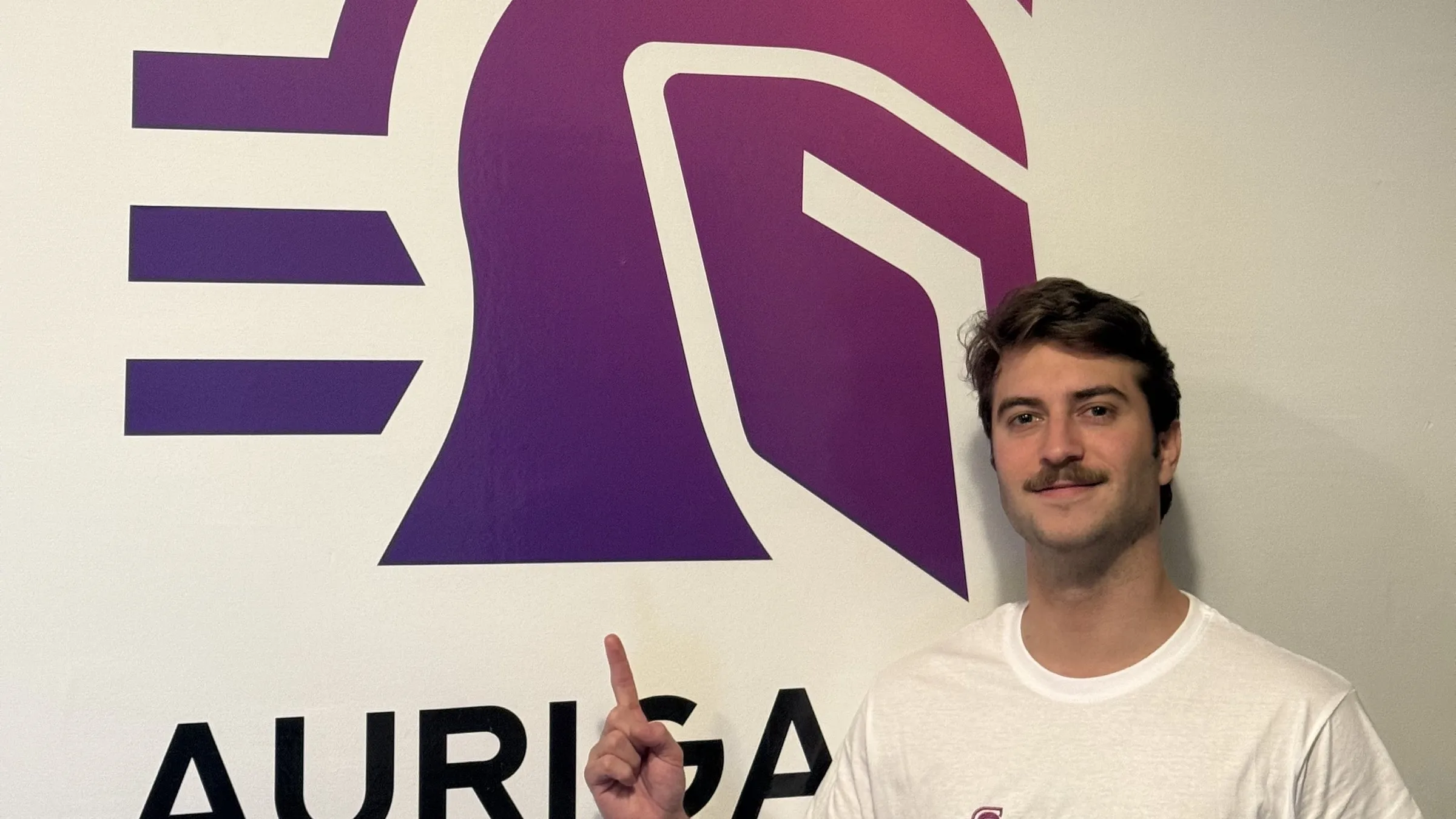 Arnau Baldó ante el logo de Auriga IA